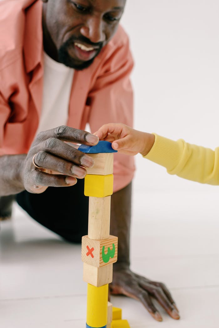 Mastering the First Impression: Your intriguing post title goes here Father and child engaging in play with colorful wooden blocks, fostering creativity and bonding.